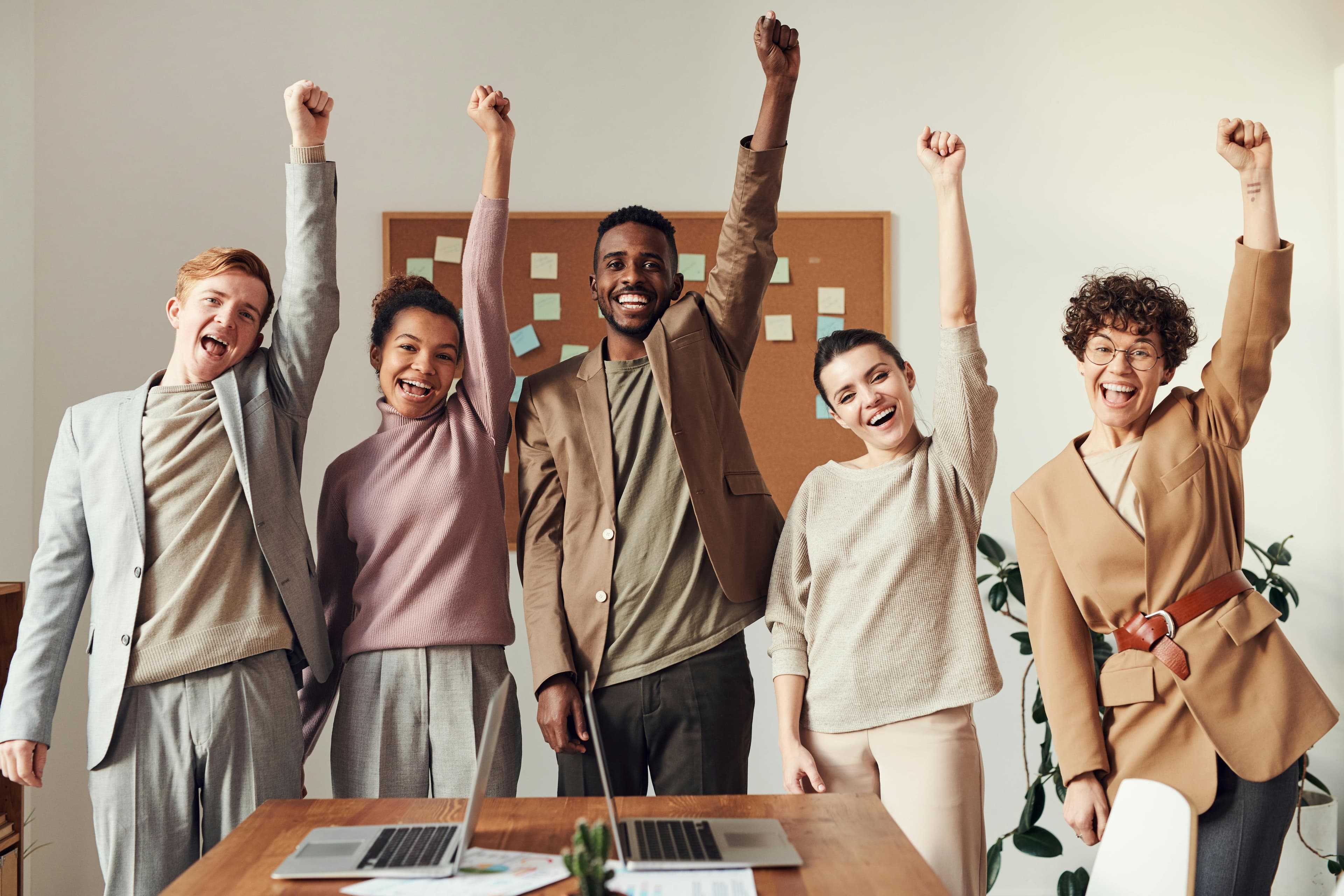 group in office raising fists in celebration